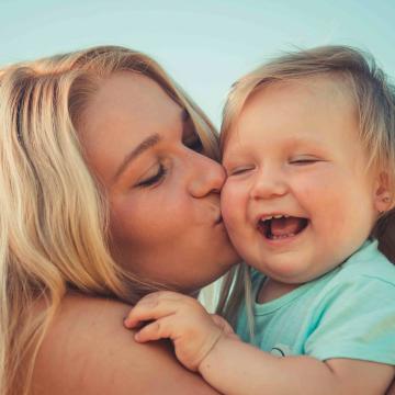 au pair gibt kleinkind einen kuss auf die wange