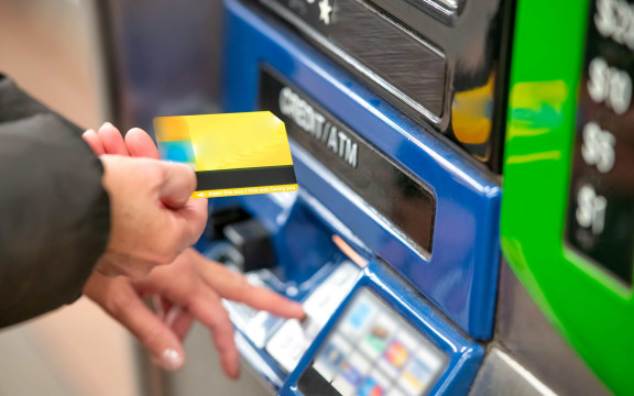 frau steht vor atm mit geldkarte