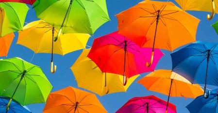 bunte regenschirme vor blauem Himmel