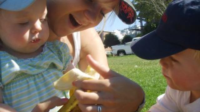 Au pair spielt draussen mit Kindern