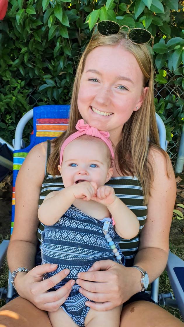 au pairs hält baby auf dem schoß