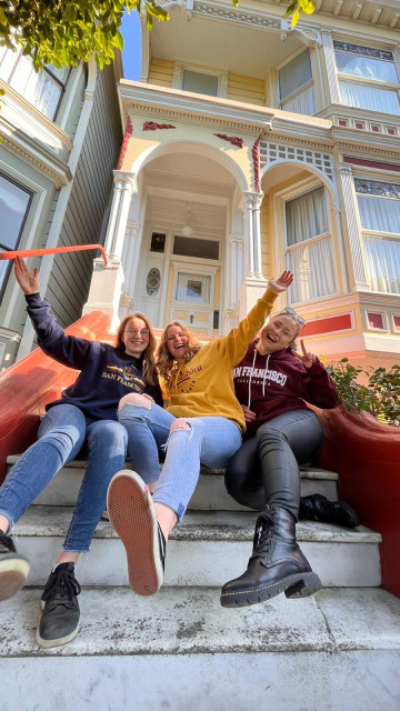 Au pairs sitzen auf der Treppe vor einem Haus