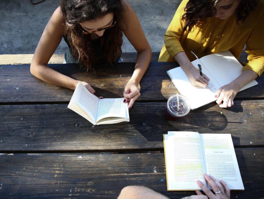 Drei Studierende sitzen am Tisch und lernen zusammen