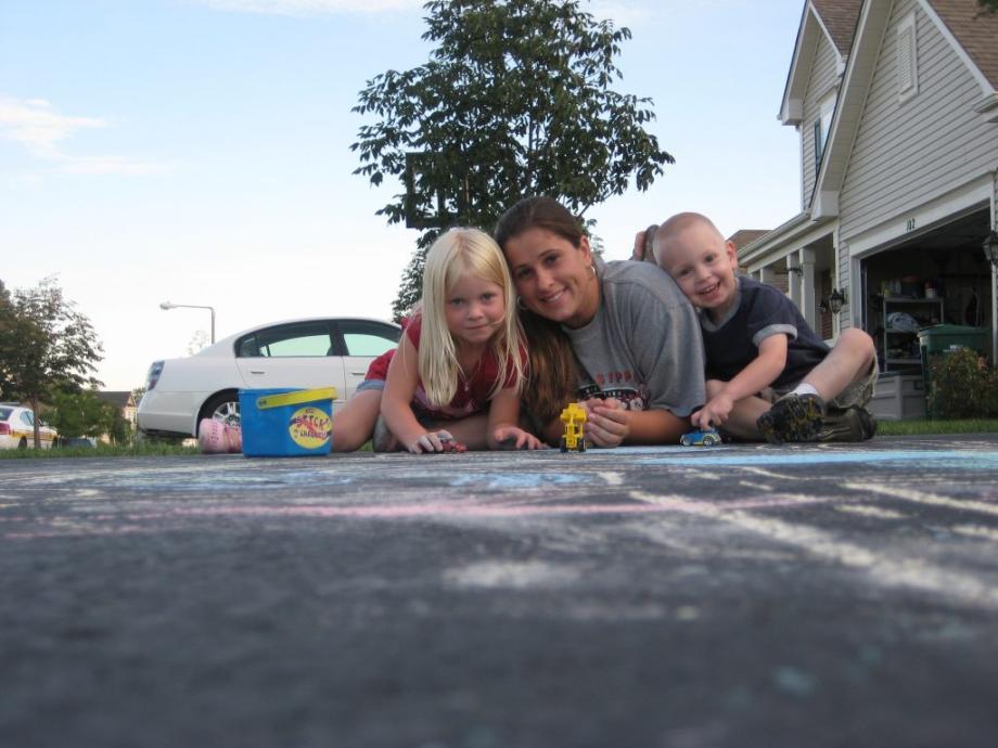 au pair malt mit gastkindern mit kreide auf der strasse