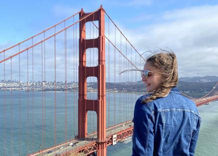 Au pair vor der Golden Gate Bridge mit dem Rücken zur Kamera