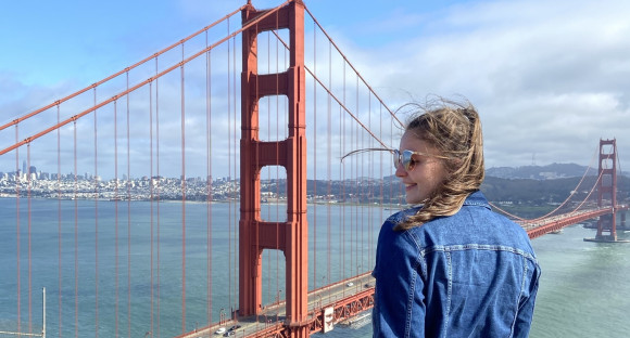Au pair vor der Golden Gate Bridge mit dem Rücken zur Kamera