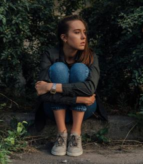 junge frau sitzt traurig auf dem boden