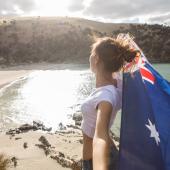 Junge Frau mit australischer Flagge am Strand