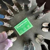 Teilnehmende stehen rund um Au pair Plakat