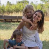 Au pair mit zwei kleinen Gastkindern auf einer Wiese