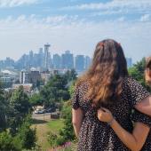 Zwei Au pairs umarmen sich und schauen auf die Skyline einer Stadt